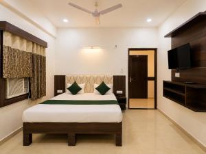 a bedroom with a bed and a flat screen tv at Hotel Pragati Palace in Mathura