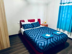 a bedroom with a bed with a blue comforter at Apartment in Port Moresby - Short Stays in Port Moresby