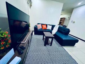a living room with a blue couch and a table at Apartment in Port Moresby - Short Stays in Port Moresby