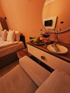 a room with a table with a plate of fruit and a mirror at novela in stone house in Uçhisar