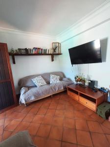 a living room with a couch and a flat screen tv at Refugio de São Luis in São Luis