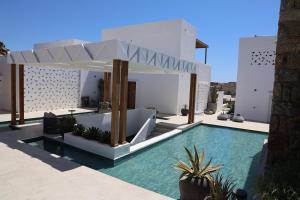 a villa with a swimming pool and a house at LYO II Boutique Suites in Mikonos