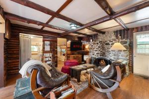 a living room with leather chairs and a stone fireplace at Spa Nature & Mountain - Le Pinacle in Frelighsburg