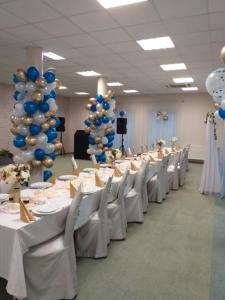 a banquet hall with white tables and blue balloons at L'ascada in Śrem +17 photos