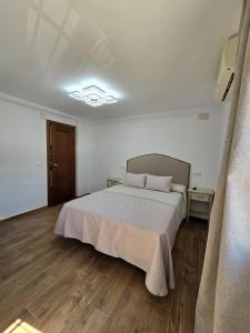 a bedroom with a bed and a light on the ceiling at Hostal La Mancha in Ruidera +24 photos