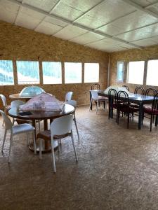 an empty room with tables and chairs and windows at Kerben Yurt Camp Arashan in Mineralʼnyy Istochnik Altyn-Arasan