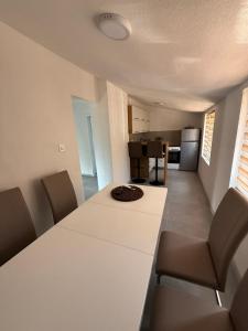 a dining room with a white table and chairs at Ivanović smeštaj in Rose