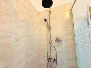 a shower with a shower head in a bathroom at L'Observatoire Vue Château in Foix +25 photos