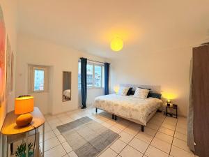 a bedroom with a bed and a large window at L'Observatoire Vue Château in Foix