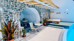 a room with a wall with a table and chairs at Loucas on the Cliff in Fira