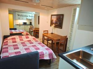 a room with two beds and a table and a kitchen at Central City nest in Haparanda