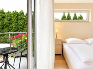 a bedroom with a bed and a balcony with flowers at HORN Jastarnia in Jastarnia +70 photos