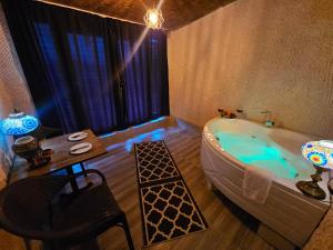 a bathroom with a bath tub and a table and a tableablish at novela in stone house in Uçhisar +49 photos