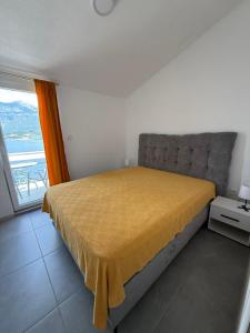 a bedroom with a bed with a yellow blanket on it at Ivanović smeštaj in Rose