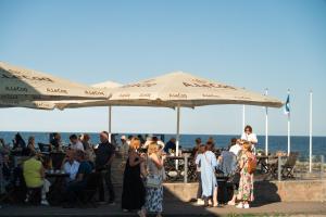 a group of people standing under an umbrella at the beach at Viinistu Art Hotel in Viinistu +56 photos