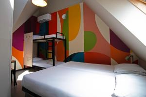 a bedroom with a colorful wall with a bed at Stayokay Hostel Rotterdam - fully renovated April 2026 in Rotterdam +21 photos