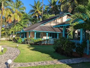 a house with blue trim and palm trees at Villas Palmar Residence Beachfront Villas & Studios in Las Terrenas