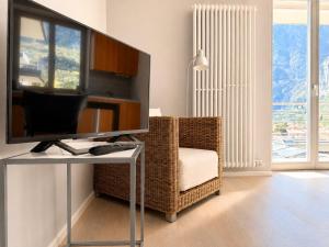 a living room with a television and a chair at View & Chill Apartment in Riva del Garda