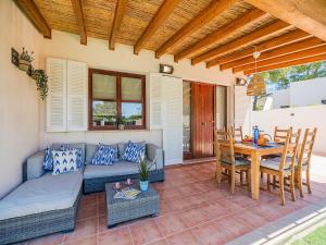 a patio with a couch and a table and chairs at 3-Bed Villa with Pool, Puerto Pollença in Port de Pollensa
