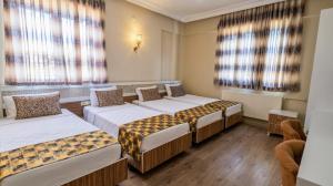 a room with four beds in a room at Grand Gülizar Otel in Urfa +35 photos