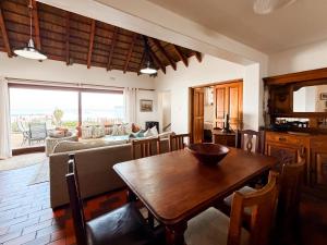 a kitchen and living room with a wooden table at Far Niente Beachfront Guesthouse in Wilderness +68 photos