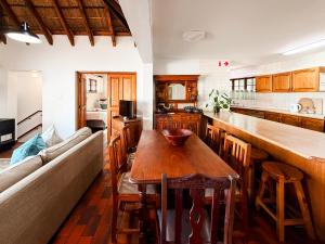 a kitchen with a wooden table and a couch at Far Niente Beachfront Guesthouse in Wilderness