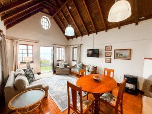 a living room with a couch and a table at Far Niente Beachfront Guesthouse in Wilderness
