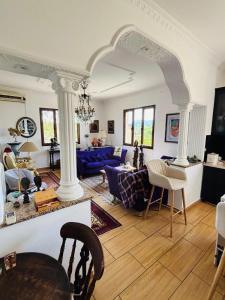 a living room with white columns and a blue couch at Hostel Calao in Shkodër