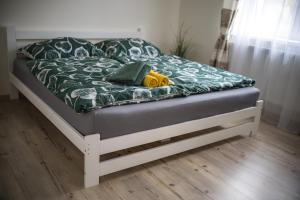 a bed with a black and white comforter on it at H apartmán Jankov in Jankov
