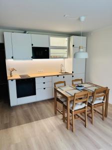 a kitchen and dining room with a table and chairs at Taagepera Guest Apartment in Taagepera