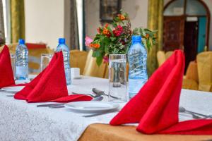 a table with red napkins and bottles of water at Stardom Hotel in Nairobi