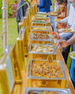 a long buffet line with many plates of food at Stardom Hotel in Nairobi