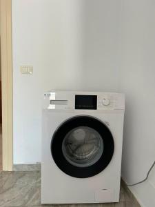 a white washing machine with its door open at Vila Zisi Himare in Himare