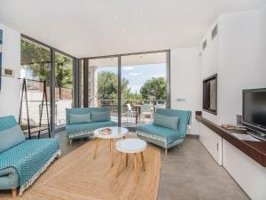 a living room with two blue chairs and a tv at Playa de Muro Chalet with Pool for 6 in Playa de Muro