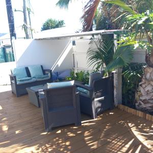 a deck with chairs and a couch and a table at La Minaude in Saint-Denis