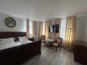 a hotel room with a bed and a table and chairs at DREI SEEN HOTEL BRANDENBURG in Lindow Ratskeller in Lindow