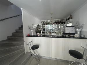 a bar with a counter with stools and a staircase at DREI SEEN HOTEL BRANDENBURG in Lindow Ratskeller in Lindow
