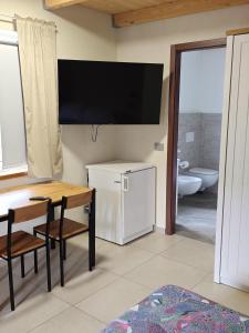 a living room with a table and a television on the wall at Residence Moulin in Aymavilles