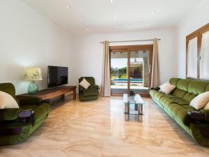 a living room with a green couch and a television at Modern Rustic Country Villa with Pool in Lloseta