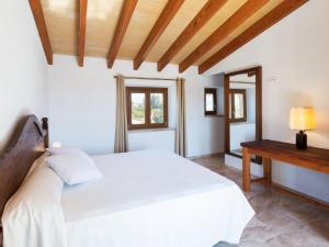 a bedroom with a white bed and a table at Modern Rustic Country Villa with Pool in Lloseta