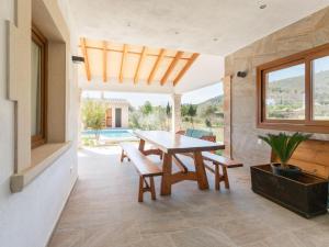 a dining room with a wooden table and benches at Modern Rustic Country Villa with Pool in Lloseta