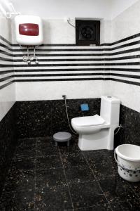 a bathroom with a toilet and a sink at The Oak Lake Cottage Boho in Nainital