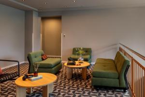 a waiting room with two chairs and two tables at Bob W Dortmund Stadtmitte in Dortmund