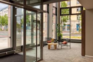a lobby with glass doors and a table and chairs at Bob W Dortmund Stadtmitte in Dortmund