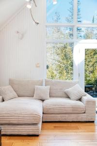 a couch in a living room with a large window at Spa & River - Chalet de la riviere Pauze in Chertsey