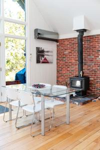 a glass table and chairs in a room with a fireplace at Spa & River - Chalet de la riviere Pauze in Chertsey