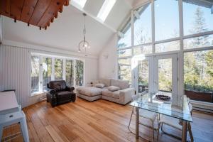 a living room with a table and a couch at Spa & River - Chalet de la riviere Pauze in Chertsey
