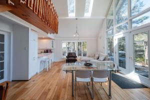 a kitchen and living room with a glass table and chairs at Spa & River - Chalet de la riviere Pauze in Chertsey +25 photos