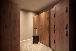 a locker room with wooden cabinets and a suitcase in it at Bob W Dortmund Stadtmitte in Dortmund