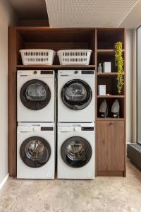 three washing machines are stacked in a laundry room at Bob W Dortmund Stadtmitte in Dortmund +40 photos